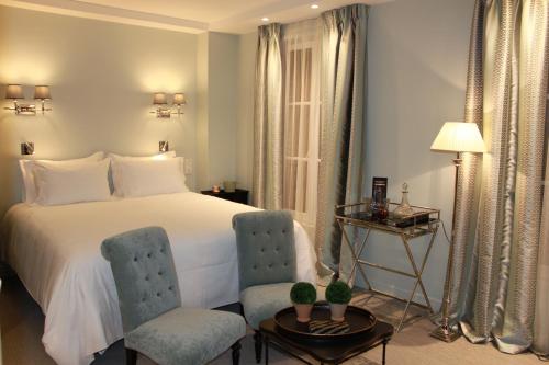 巴黎我家在巴黎酒店的卧室配有一张床和一张桌子及椅子