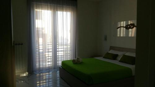 切萨雷奥港B&B La Laguna的一间卧室设有一张绿色的床和一个大窗户