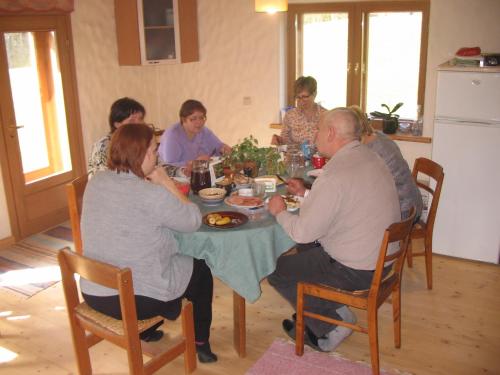 EosteKõrgemäe puhketalu的一群坐在桌子旁吃食物的人