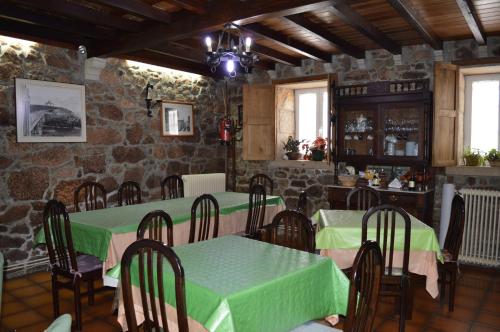 卡尔达斯·德·雷斯Casa Loureiro的一间带桌椅和石墙的用餐室