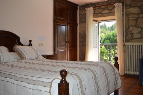 卡尔达斯·德·雷斯Casa Loureiro的一间卧室设有一张床和一个大窗户