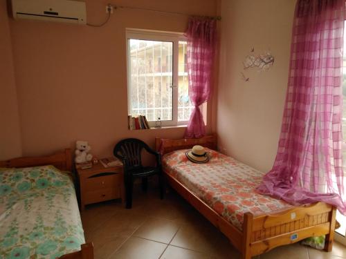 DhílesiDimitri's house的一间卧室设有两张单人床和一扇窗户。