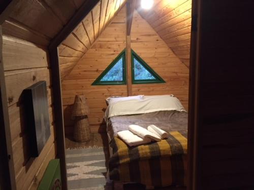 伊塔蒙蒂Delirius Hospedagem的小木屋设有1间带1张床的卧室和窗户
