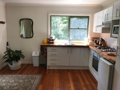 BilpinGhost Hill Road Retreat的厨房配有白色橱柜和窗户。