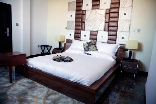 亚的斯亚贝巴Afropolitan Hotel的一间卧室配有一张大床和木制床头板
