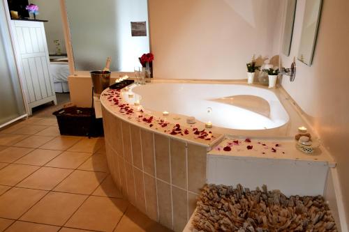韦尔德里夫Riviera Hotel & Chalets的浴室内设有一个浴缸,四周有鲜花