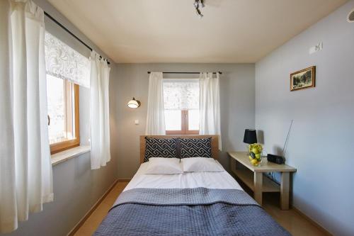 考斯赛力克Liliowe Turnie Kościelisko的一间小卧室,配有床和2个窗户