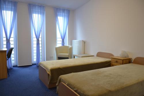 华沙Warszawa Stare Bielany的酒店客房,设有两张床和蓝色窗帘