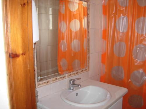 卡尔扎迈纳菲利波斯公寓酒店的浴室设有橙色淋浴帘和水槽