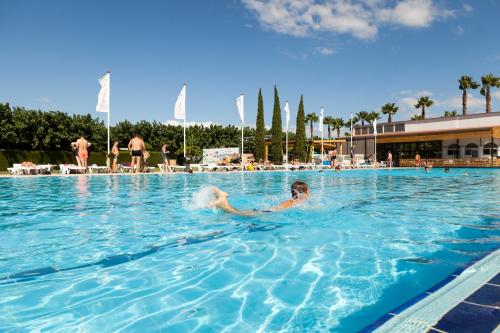 坎布里尔斯普拉亚坎布里尔斯露营酒店的在游泳池游泳的人