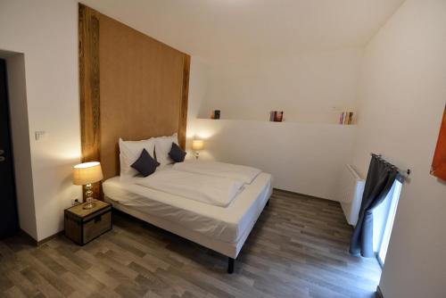 埃圭斯海姆Gîte au château fleuri的一间卧室配有一张床和一盏灯,铺有木地板