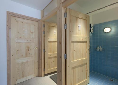 曼谷平托青旅的浴室设有木门和蓝色瓷砖。