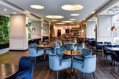 维尔纽斯维尔纽斯艾伯顿大教堂广场酒店的一间设有蓝色桌椅和桌面的餐厅