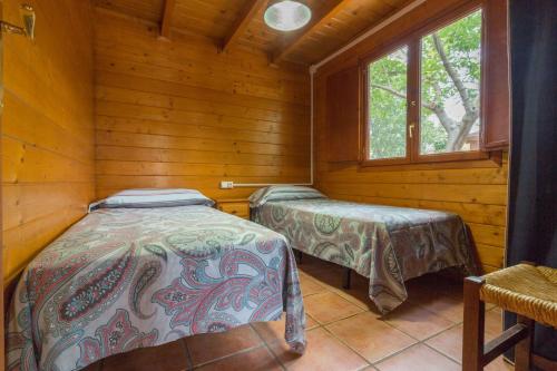 Luchente马斯德泽特酒店的小木屋内一间卧室,配有两张床