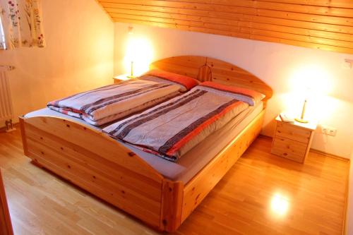 温特贝格Appartement Landelijke Star的卧室内的木床,配有两盏台灯