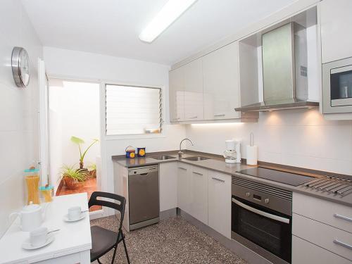 滨海圣波尔Apartment Sant Pol by Interhome的厨房配有白色橱柜和炉灶烤箱。