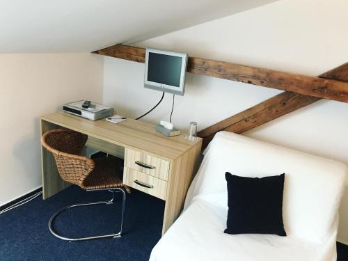 俄斯特拉发DMZ膳宿旅馆的客房设有一张床、一张桌子和一台电脑