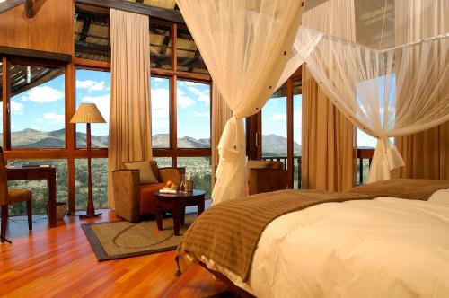 GocheganasGocheganas Lodge的一间卧室设有一张床和大窗户