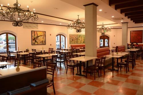 莱昂Hotel La Recolección的用餐室配有桌椅和吊灯。