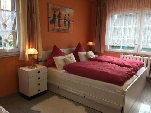 布尔格Ferienwohnung Rosi Stoppa的一间卧室配有一张带红色床单和枕头的床。