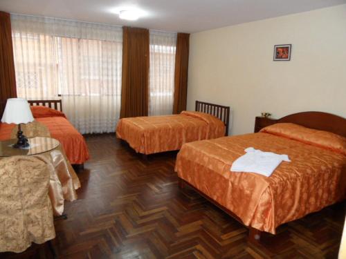 特鲁希略博纳尼特旅馆的酒店客房设有两张床和一张桌子。