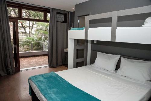 里约热内卢REF House Barra Da Tijuca的一间带两张双层床的卧室和一个阳台