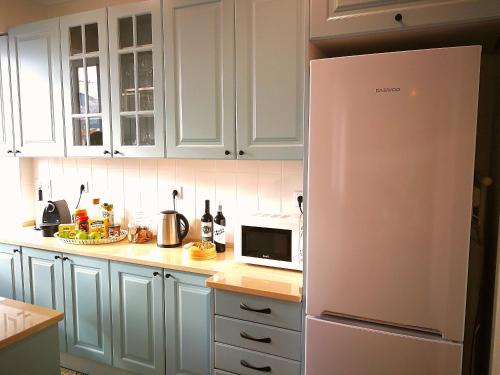 里斯本The sunset Lisbon flat的厨房配有白色橱柜和冰箱。