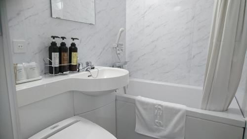 松山松山终端酒店的白色的浴室设有卫生间和水槽。