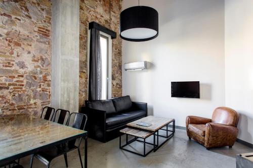 巴塞罗那巴塞罗那共和公寓酒店的客厅配有黑色真皮沙发和桌子