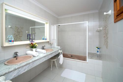休达德亚Sa Legitima的浴室配有2个盥洗盆、淋浴和浴缸。