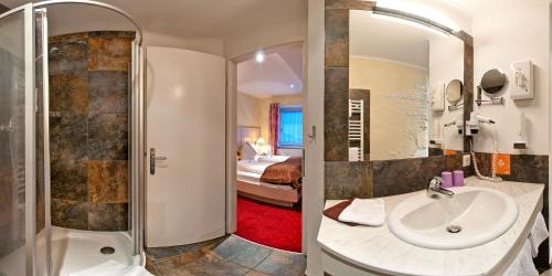 TrebesingSmileys Kinderhotel的一间带水槽和淋浴的浴室以及一间卧室