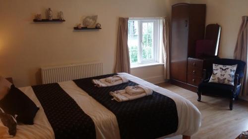 文特诺Kingsmede Bed & Breakfast的一间卧室配有一张床,上面有两条毛巾