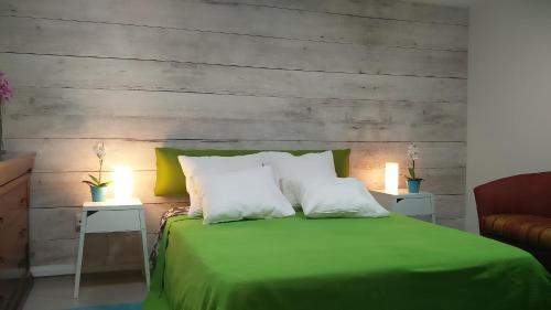 GederaLike Home Gedera的一张绿色的床,配有两个白色枕头和两张桌子