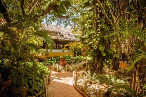 塞古罗港Casa Blanca Park Hotel的一座种植了树木和植物的花园,一座建筑