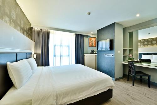 曼谷Prestige Suites Nana的配有一张床和一张书桌的酒店客房