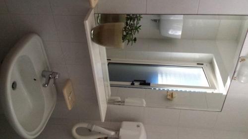 圣多米诺紫罗兰酒店的一间带水槽和卫生间的浴室以及窗户。