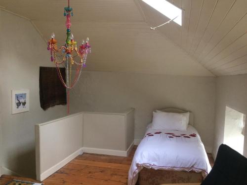 纳文The Groom's Cottage的一间卧室配有一张带吊灯的床
