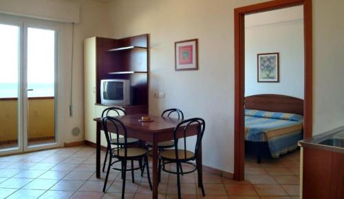 里米尼Residence Carioca的一间带桌椅的房间和一间卧室
