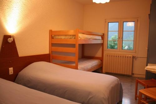 欧龙欧龙科莱酒店的一间卧室设有两张双层床和一扇窗户。