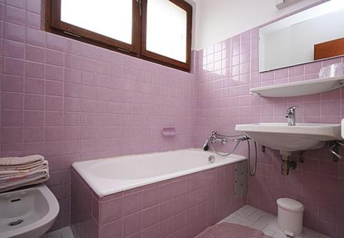 沙泰勒喀斯特兰酒店的粉红色的浴室设有浴缸和水槽