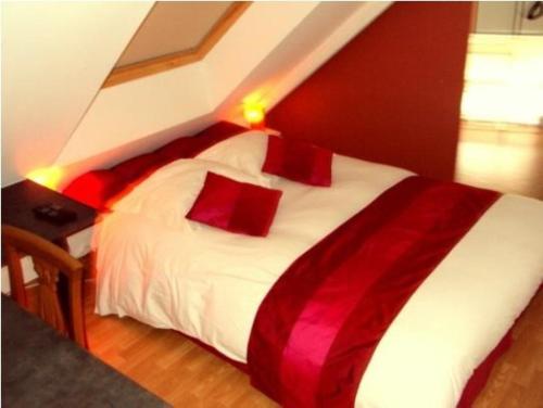 奎恩安杜娜荣旅馆的卧室配有带红色枕头的白色床