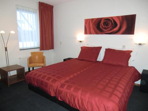 哈登贝赫豪尔斯泰勒瑞瑞泽维恩酒店的酒店客房设有一张红色的床,墙上挂着红玫瑰