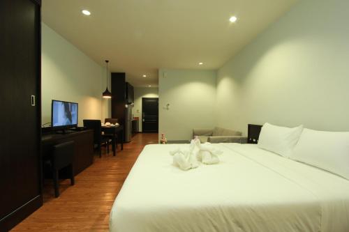 Si Maha Phot公园304行政服务式公寓 的一间带白色大床的卧室和一间客厅