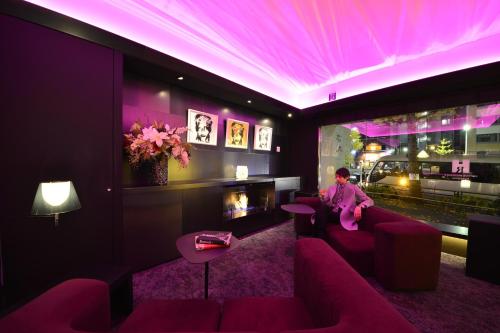 东京六本木S酒店的坐在紫色灯光的房间沙发上的女人