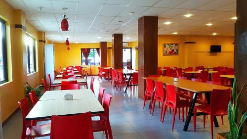 BoronganDomsowir Hotel and Restaurant的用餐室配有桌子和红色椅子