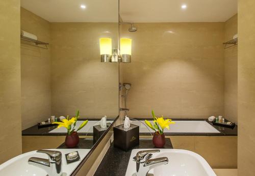 斋浦尔KK Royal Hotel & Convention Centre的浴室配有两个盥洗盆和浴缸。