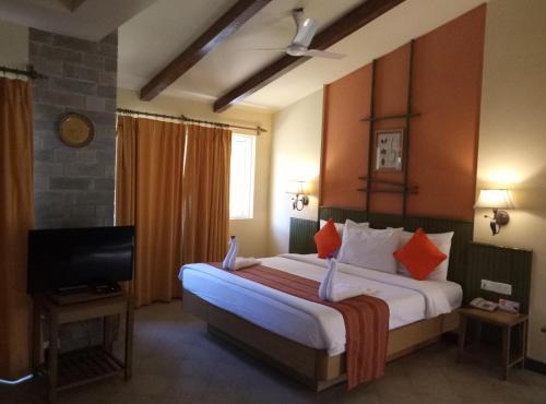 宾萨尔Club Mahindra Binsar Valley的酒店客房设有一张大床和一台电视。
