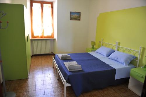 马罗内Appartamento Al Ponte的一间卧室配有蓝色的床和毛巾