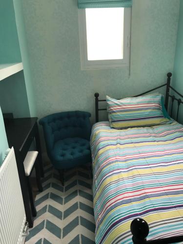 巴斯2 bed, ground floor Bijou Georgian city apartment的一间卧室配有一张床和一张蓝色椅子