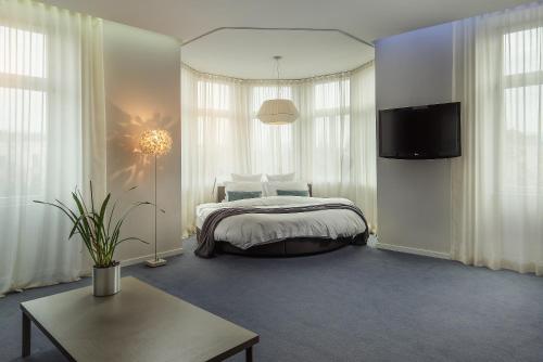 卢布尔雅那库伯酒店的一间卧室配有一张床和一台电视。